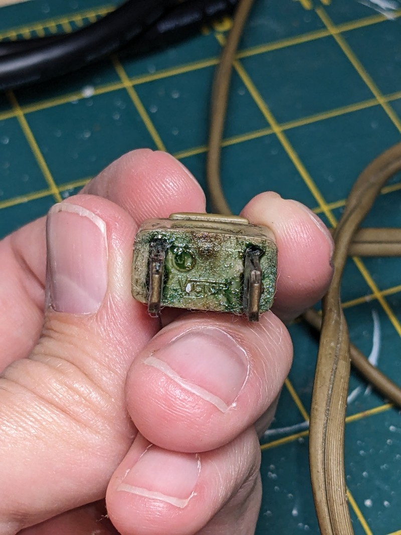 Electric cord plug with green goo indicating the insulation is breaking down inside.